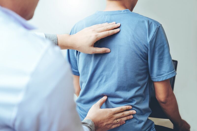 doctor checking patient with spinal injury