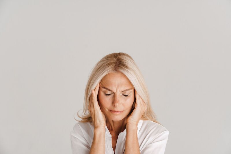 woman with headache holding her head