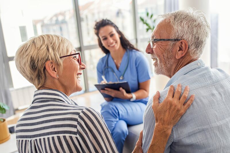happy older couple meeting with doctor